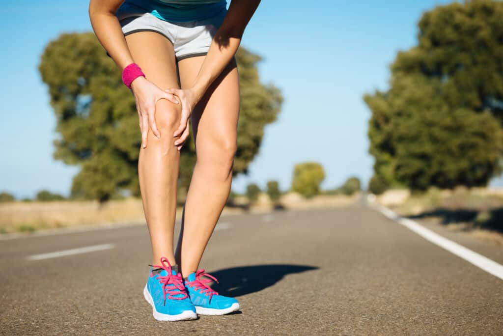 Exploring the 5 Common Causes of Knee Pain. Female runner knee injury and pain.